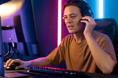 Kazanmak için çevrimiçi oyun oynayan akıllı flama makinesinin sunucu kanalı, neon ışıklı odada seçilen takım yarışması için izleyicilerle birlikte canlı yayında canlı yayında kulaklık takıyor. Bireysel.