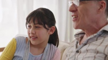 Büyükbaba ve torun birlikte TV 'de ilginç bir eğlence medyası izliyorlar. Eski üst düzey kullanım teknolojisi, genç nesil çapraz nesil ile iletişim kurarak aile bağlarını güçlendiriyor. Uyumsuzluk.