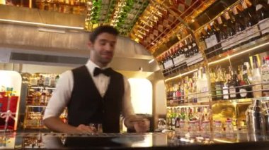 Akıllı barmen, lüks bir tezgahta arkadaşını beklerken limonlu cin kokteyli ikram ediyor. Barmen, canlı gece hayatı parti atmosferinde mükemmel hizmet veriyor. Vinosity.