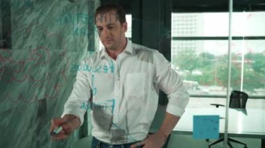 Profesyonel erkek lider yapışkan notlar üzerine pazarlama fikri yazıyor. Kafkasyalı işadamı cam duvarda renkli yapışkan notlar kullanırken pazarlama kampanyasını düşünüyor. - Yakın çekim. Yönlendirici.