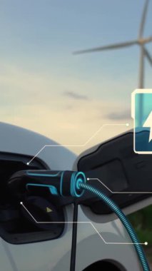 Elektrikli araba, EV şarj istasyonundan enerji alıyor. Rüzgar türbini çiftliğinde EV şarj kablosu kablosunun fütüristik akıllı batarya durum hologramını gösteriyor. Alternatif temiz enerji sürdürülebilirliği. İnceleyin