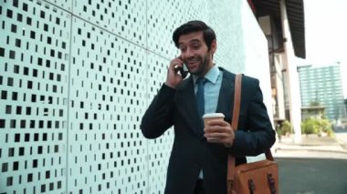 İş adamı telefona cevap verir ve iş yatırımları hakkında konuşur. İş planı, pazarlama stratejisi ya da çalışma hakkında konuşmak için akıllı telefonla konuşurken sokakta yürüyen mutlu bir yönetici. Sevinçli..