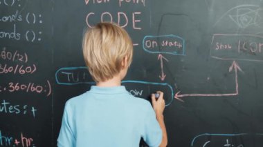 Tahtaya yazı yazan öğrencilerin arka planı. Yakışıklı zeki çocuk ya da çocuk BTMM teknoloji sınıfında kodlama ve programlama sistemi kullanarak bir proje planlıyor. - Yakın çekim. Etkinlik.