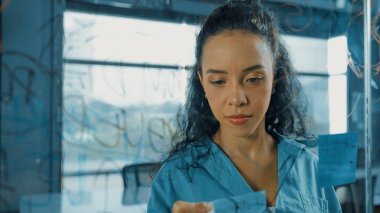 Genç İspanyol çalışanlar renkli yapışkan notlar yazıyorlar. Akıllı iş kadını pazarlama fikrini, beyin fırtınası stratejisini, iş planını paylaşıyor. Proje yöneticisi zihin haritası çiziyor. - Yakın çekim. Yönlendirici.