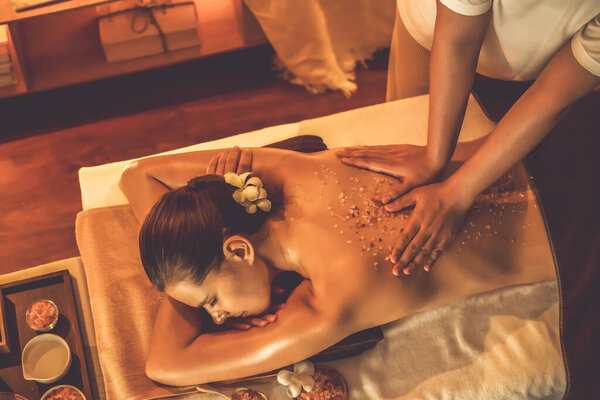Женщина-клиент, проводящая пилинг в роскошном спа-салоне с теплым свечой окружающей среды. Косметическое лечение бальзамическим скрабом в Health spa scrub. Quiescent
