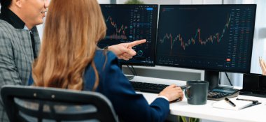 Panoramik fotoğraf Asyalı iş ortakları bilgisayar ekranı değer oranı online web sitesi programındaki dinamik borsa verilerine işaret ediyorlar. Yatırımcı, finansal durumu tam zamanında gösteriyor. İnfobahn.