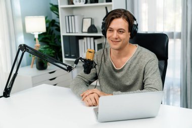 Sunucu kanalı, gülümseyen akıllı yayıncı kaydı, senaryosu ve akıllı telefonuyla sosyal medyada sohbet programı, kulaklık takarak modern ev stüdyosundaki video flamalarını kaydediyor. Bireysel.