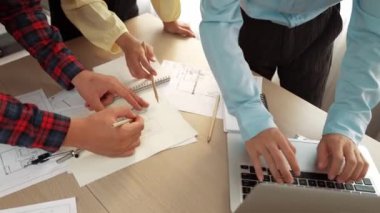 Mimarlık ve güvenlik mühendisi, modern ofiste doğruluk için mimari belge ve ölçüm aracı kullanılarak dizüstü bilgisayarın üzerinde sergilenen planlar hakkında tartıştı. - Yakın çekim. Tanımlama.