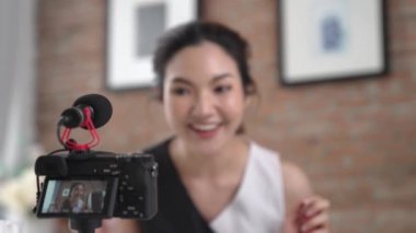 Kadın nüfuzlu kişi canlı yayın yapan video görüntülerini sosyal medya ya da blog üzerinden gözden geçiriyor. Kozmetik stüdyosu ışıklandırmalı mutlu genç kız çevrimiçi pazarlama oturumu yayını için..