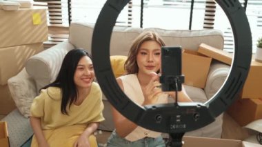 Oturma odasında canlı yayında ürün gösterilirken birkaç etkili kişi yayında. Evde ürün satarken blogger kaydeden çekici bir çift. Çevrimiçi pazarlama konsepti. Myrmidon.