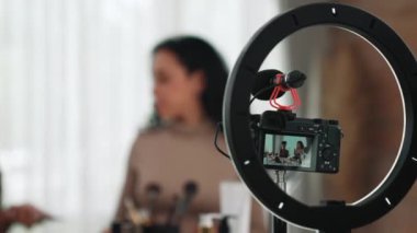 Arka plan kamera görüntüsü, iki kadın nüfuzlu kişinin canlı yayın yapan video görüntülerini kaydediyor. Makyaj, sosyal medya ya da blog. Çevrimiçi pazarlama yayını için kozmetik ürünleri olan genç bir kız.