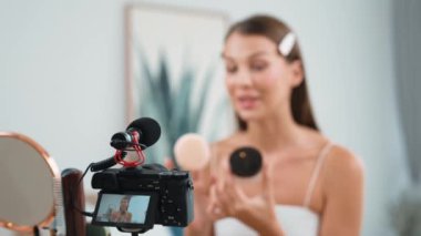 Sosyal medya için güzellik ve kozmetik video içeriği hazırlayan genç bir kadın. Güzellik blogcusu kameraya gülümserken seyircilere ve takipçilere güzellik bakımını gösteriyor. Düzenle