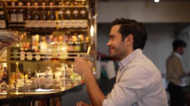 Eski usulde gülümseyen akıllı adam kokteyl içerken, barmen de özel içkiler hazırlıyor. Cuma gecesi lüks bir gişede, gece kulübünde, canlı bir içecekle servis yapmak için sallanıyor. Vinosity.