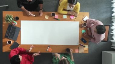 Toplantı masasında takım tasarım ve planlama projesinin zaman aşımına uğraması ve toplantı masasındaki kağıdı yapışkan notlar ve dizüstü bilgisayarla işaretlemesi. Çeşitli gruplar pazarlama fikrini paylaşıyor. Cemaat.