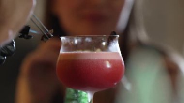 Barmenin tarçın yakmasına karışık votka kokteyline odaklanmak özel gece kulübü barında gece vakti bulanık gülümseyen güzel bir müşterinin VIP gruplarına lezzet katmak. Vinosity.