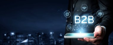 İş adamı B2B peyzajında geziniyor, iş-iş bağlantılarını geliştirmek için kullanım teknolojisi kullanıyor. B2B etkileşimlerini yeniden şekillendirir, iş stratejilerindeki yenilikleri tetikler. FaaS