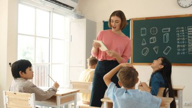 Sınıfta çeşitli çocuklar sınıf ödevlerini yaparken, Kafkasyalı öğretmen sınıfta yürüyor ve öğrenci ödevlerini kontrol ediyor. Çeşitli zeki öğrenciler ilkokulda ders veriyor ve not alıyor. Pedagoji.