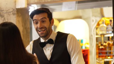 Gülümseyen zeki barmen, gece kulübünde VIP müşterilerle canlı sohbetler yapmak için güzel bir gece partisi atmosferine mükemmel bir servis sunuyor. Vinosity.