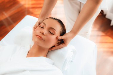 Kafkasyalı kadın stres önleyici kafa masajından ve lüks tatil beldesi ya da otel spa salonundaki modern ışık ortamında yüz güzelliği eğlencelerini şımartmaktan hoşlanıyor. Sessiz.