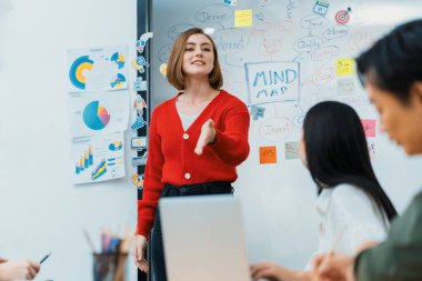 Profesyonel çekici kadın lider, modern iş toplantı odasında beyin fırtınası zihin haritalama istatistikleri ve renkli yapışkan notlar kullanarak yaratıcı pazarlama planını sunuyor. Tertemiz..