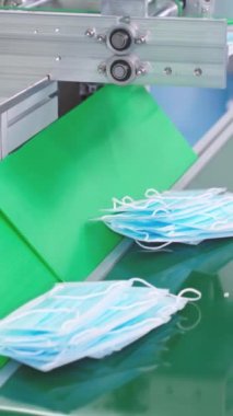 Modern fabrikada yüz maskesi üretim hattı. Covid-19 Coronavirus 2019 üretimi kavramı .