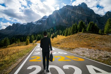 2025 yılbaşı yolculuğu ve gelecek vizyon konsepti. 2025 'in başında mutlu bir yeni yıl kutlaması için otoyolda ilerleyen iş adamı. .