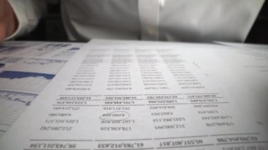 Muhasebeci, ofis masasındaki kağıt torpido gözünde iş pazarlama verilerini analiz ediyor. Şirket finans ve para muhasebe kavramı.