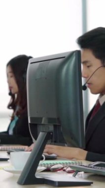 Ofiste çalışan kulaklık takan işadamları uzak müşteri ya da meslektaşlarını desteklemek için çalışıyorlar. Arama merkezi, tele pazarlama, müşteri destek acentesi telefon görüşmesinde hizmet sunar.