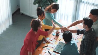 Başarılı bir projeyi kutlamak için el ele tutuşurken cep telefonu için tablet görüntüleme web sitesi prototipi üzerinde çalışan akıllı geliştiricinin üst görünümü. Takım el ele tutuşuyor. Sempozyum.