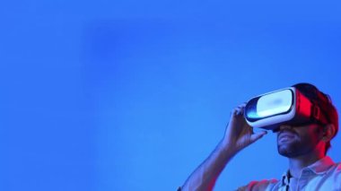 Heyecanlı adam sanal gerçeklik gözlüğü kullanarak küresel bağlantı hologramına bakıyor. Yetenekli yatırımcılar küresel iletişimi ve ağ bağlantısı hologramını inceliyor. Teknoloji. Aygıt.