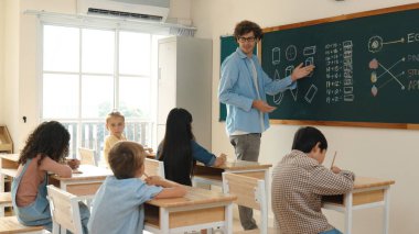 Öğrenci ödevlerine bakarken sınıfta yürüyen yetenekli bir öğretmen. Sınav yaparken ya da sınıfta ödev yaparken akıllı çocuk defterini kontrol eden profesyonel bir eğitmen. Pedagoji.