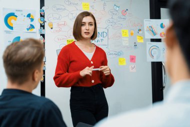 Profesyonel çekici kadın lider, modern iş toplantı odasında beyin fırtınası zihin haritalama istatistikleri ve renkli yapışkan notlar kullanarak yaratıcı pazarlama planını sunuyor. Tertemiz..