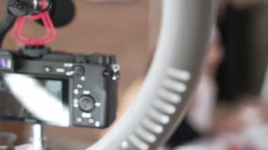 Kadın nüfuzlu kişi canlı yayın yapan video görüntülerini sosyal medya ya da blog üzerinden gözden geçiriyor. Kozmetik stüdyosu ışıklandırmalı mutlu genç kız çevrimiçi pazarlama oturumu yayını için..