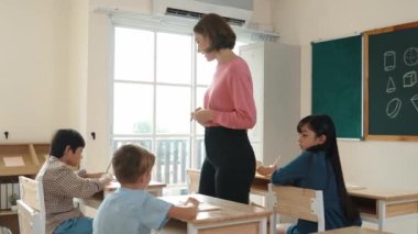 Sınıfta çeşitli çocuklar sınıf ödevlerini yaparken, Kafkasyalı öğretmen sınıfta yürüyor ve öğrenci ödevlerini kontrol ediyor. Çeşitli zeki öğrenciler ilkokulda ders veriyor ve not alıyor. Pedagoji.