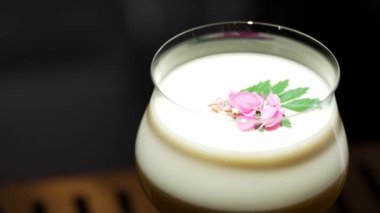 Tutkulu meyve suyu bardağında dönüşümlü, özel, ferahlatıcı, pembe çiçekle süslenmiş, lüks gece klübünde gece hayatı karışımı sergilenen bir içecek. Vinosity.