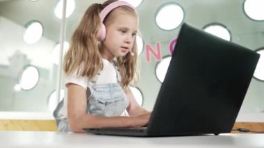 Dizüstü bilgisayarda çalışan ya da online sınıfta okuyan genç bir öğrenci. Ev ödevi yaparken ya da müzik dinlerken bilgisayarda yazan beyaz bir kız. Kulaklık takan küçük bir çocuk. Yaratıcı öğrenme. Etkinlik.