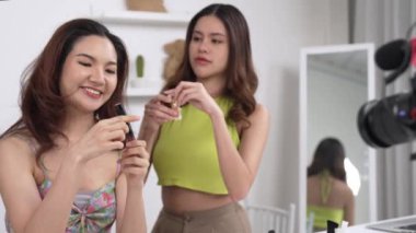 Etkilenen iki ortak canlı yayın yapan video görüntülerini sosyal medya ya da blog üzerinden gözden geçirir. Canlı kozmetik stüdyosu ışıklandırması olan mutlu genç bir kız pazarlama için internet üzerinden yayın yapıyor..