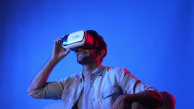 VR gözlük takan zeki bir adam ve metaevrene girmek için heyecanlı. Çekici oyuncu sanal gerçeklik dünyasını bağlarken ve hareket ederken veya etrafa bakarken fantezi oyunu oynuyor. Eğlence için. Aygıt.