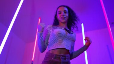 Latin dansçıların kameraya bakıp şehrin pop müziğiyle dans ettiği düşük açılı kamera. Profesyonel çekici hipster, mor veya neon ışıklı hip hop şarkısına geçiyor. Şık bir kumaş. Mutluluk.