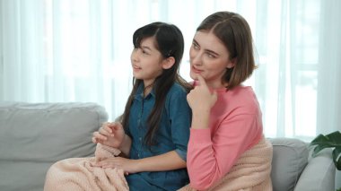 Annesi peri masalı anlatırken, mutlu kız beyaz annelerin kucağında oturuyor. Anne, kızı eve bakıp gülümserken ona sıcak bir şekilde sarılıyor. Aile birlikte vakit geçirir. Pedagoji.