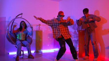 Stüdyoda gündelik kıyafetleri olan çok kültürlü bir arkadaş tezahürat yaparken mutlu hipster break dansları. Profesyonel sokak dansçısı hip hop ritmi ya da neon veya kurşun ışıkla kafiyeli bir şarkı söyler. Mutluluk.