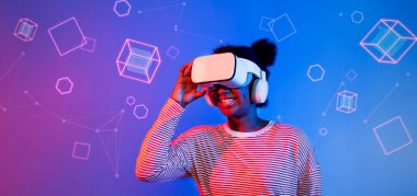 VR gözlüklü Afrikalı kız mavi ve pembe arka planda duruyor ve yüzen geometrik şekle bakıyor. Heyecanlı insan görsel gerçeklik dünyasına giriyor. Teknoloji yeniliği. Yaratıcılık.