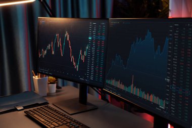Dinamik borsa grafiklerinin büyük ekranları neon ışıklı gece vakti bilgisayarda görünüyor. Finansal teknolojiye yapılan güncellenmiş yatırımla otomatik olarak satış ya da kâr satın alma. İnfobahn.