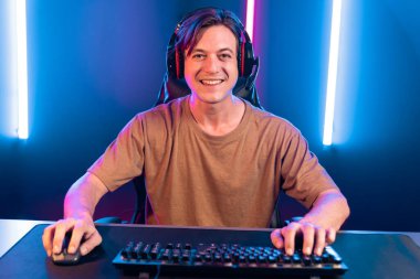 Kazanmak için çevrimiçi oyun oynayan akıllı flama makinesinin sunucu kanalı, neon ışıklı odada seçilen takım yarışması için izleyicilerle birlikte canlı yayında canlı yayında kulaklık takıyor. Bireysel.