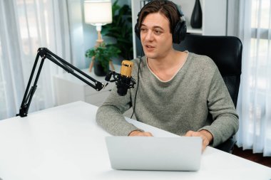 Sunucu kanalı, gülümseyen akıllı yayıncı kaydı, senaryosu ve akıllı telefonuyla sosyal medyada sohbet programı, kulaklık takarak modern ev stüdyosundaki video flamalarını kaydediyor. Bireysel.