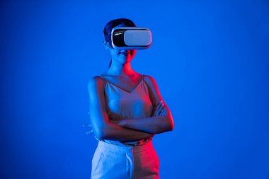 Akıllı kadın, metaevrene bağlı, fütürist siber uzay teknolojisine sahip VR kulaklık takıyor. Zarif kadın sanal alana bakarken kendine güvenerek poz veriyor. Halüsinasyon.