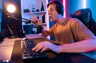 Kazanmak için çevrimiçi oyun oynayan akıllı flama makinesinin sunucu kanalı, neon ışıklı odada seçilen takım yarışması için izleyicilerle birlikte canlı yayında canlı yayında kulaklık takıyor. Bireysel.