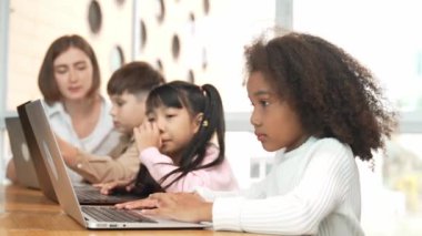 Afrikalı kız, STEM teknoloji dersinde çeşitli arkadaşlarıyla bilgisayar oyunu oynuyor. Mühendislik kodları ve bulanık geçmişi olan programlama sistemi üzerine çok kültürlü bir öğrenci çalışması. Etkinlik.