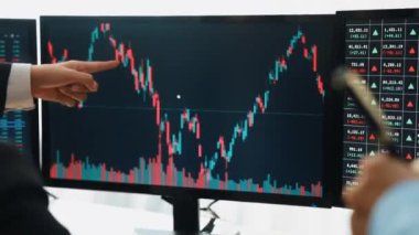 Menkul kıymetler borsası pazarlamasını inceleyen borsa yatırımcıları, zarar ve kazanç için mum bar fiyatlarını analiz eden monitörlere bakıyor. Filizlenen