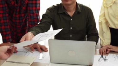 Akıllı mimar ve güvenlik mühendisi, mimari belge, ölçüm araçları ve ahşap blokların modern ofiste etrafa saçıldığı masa planlarını tartışıyor. - Yakın çekim. Tanımlama.